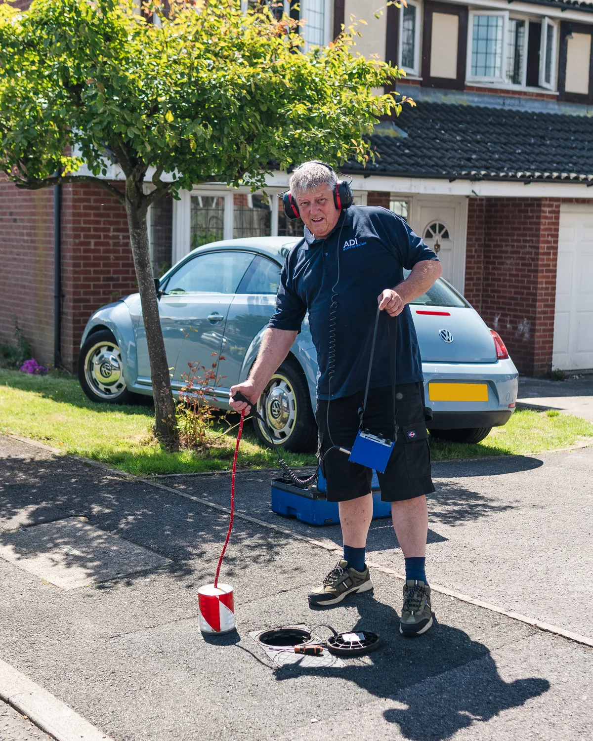 An ADI engineer using an acoustic ground microphone to listen for escaping water