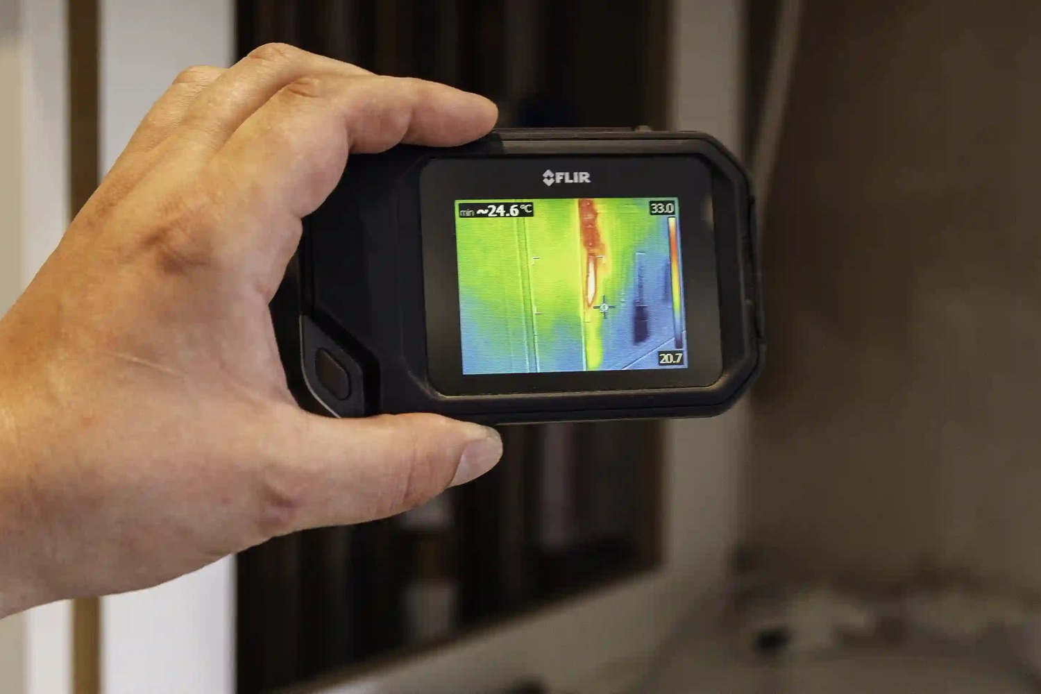 A thermal imaging camera screen showing the heat trail of a hidden hot pipe inside a wall